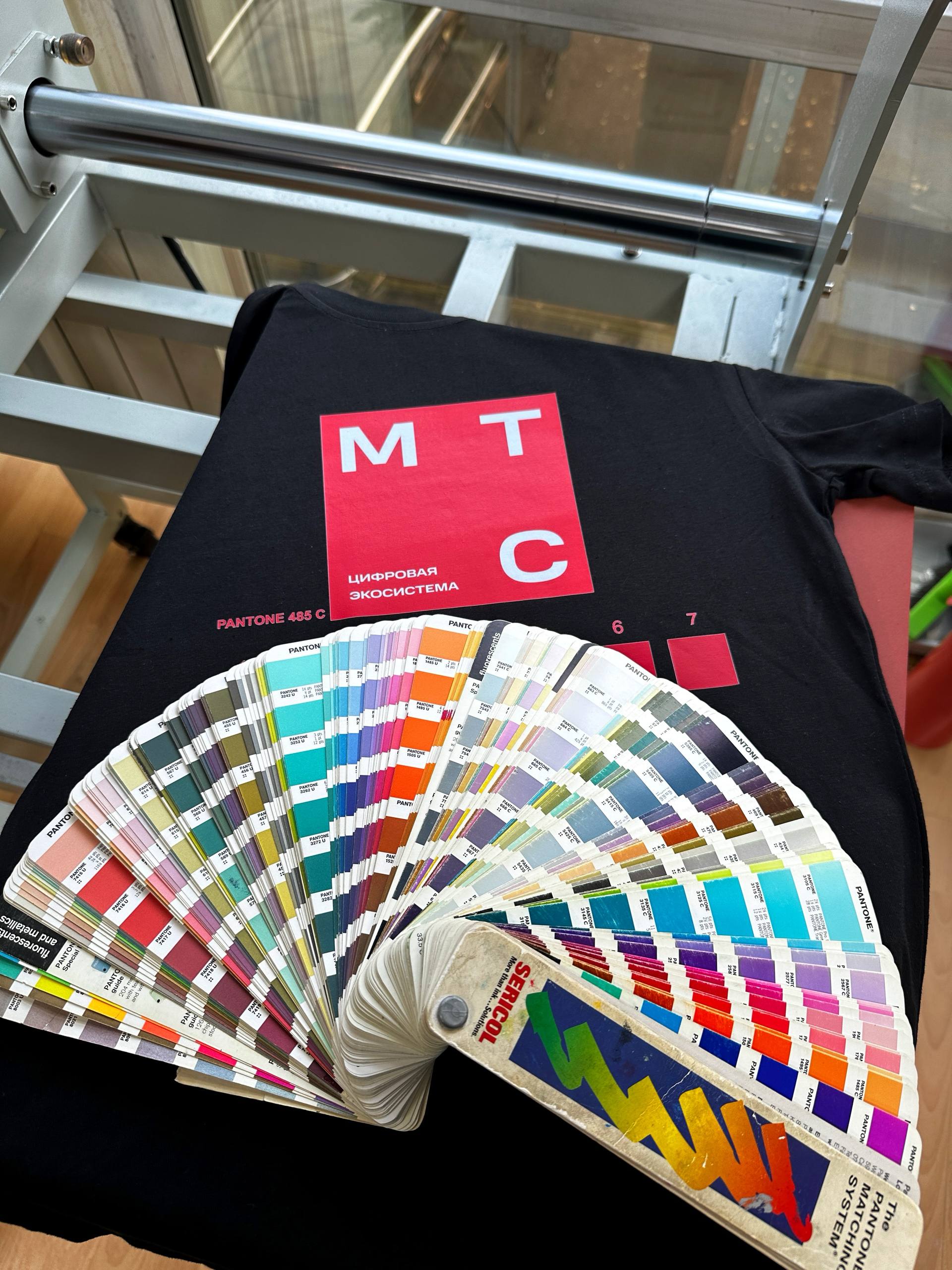 Сегодня расскажем про Pantone: как попасть «в тот самый» оттенок в мерче
На фото — наш DTF принт на чёрной футболке + веер Pantone: показываем, как попадаем в тон | Сетка — социальная сеть от hh.ru